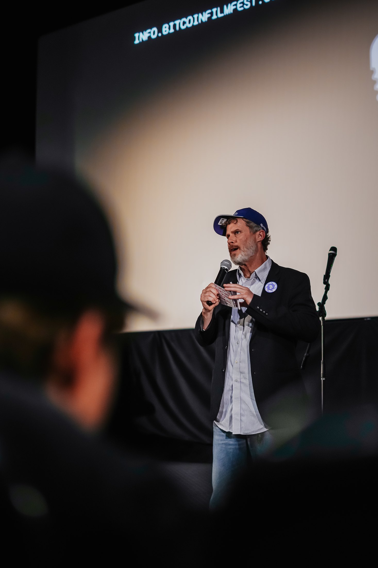 Speaker holding a microphone at Bitcoin FilmFest 2025